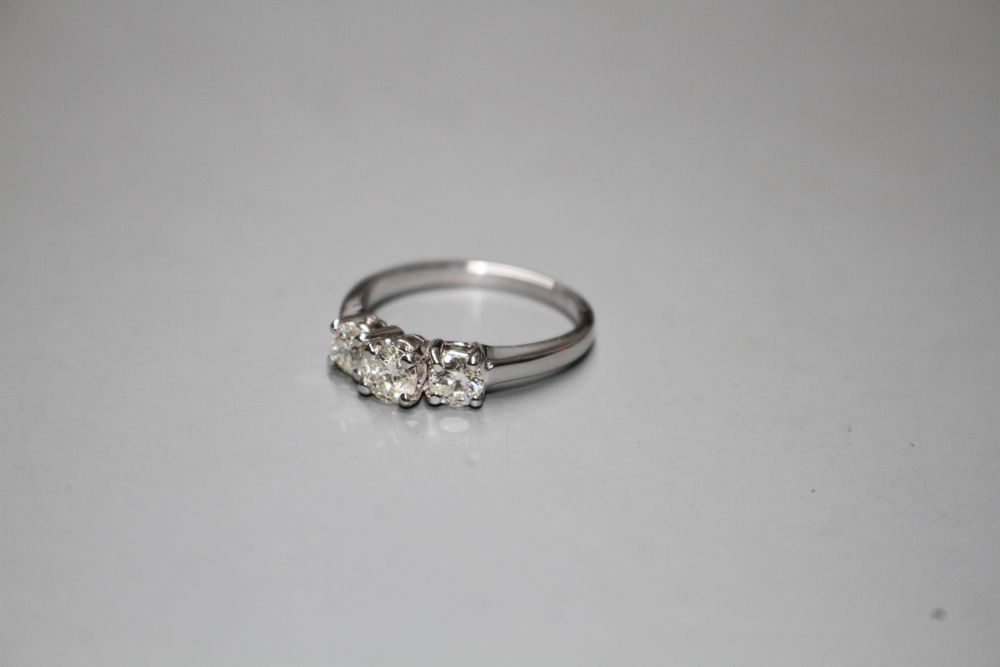 A modern 14k white metal and three stone diamond ring,